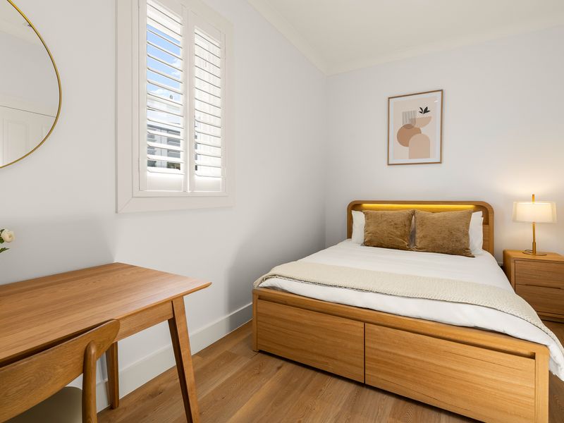 Bright bedroom with a comfortable queen bed and dedicated workspace.