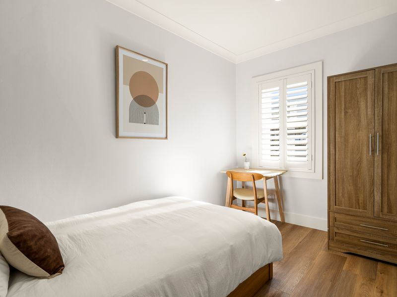 Relax in a tranquil bedroom featuring warm timber furnishings.