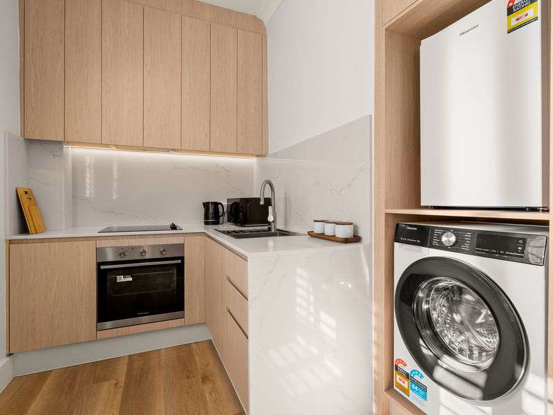 Modern kitchen with quality appliances and internal laundry facilities.