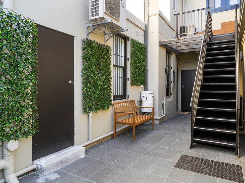 Shared courtyard entry with landscaped surroundings.