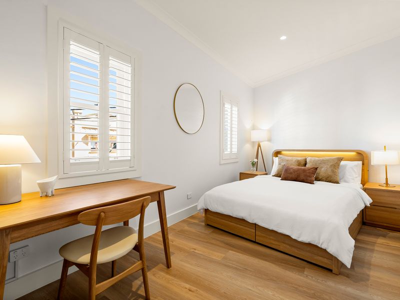 Bedroom featuring a dedicated workspace, Smart TV, and cozy queen bed.
