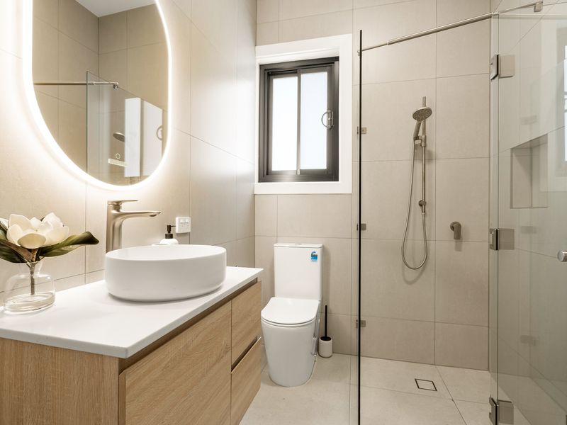 Sleek bathroom featuring a walk-in shower and modern vanity.