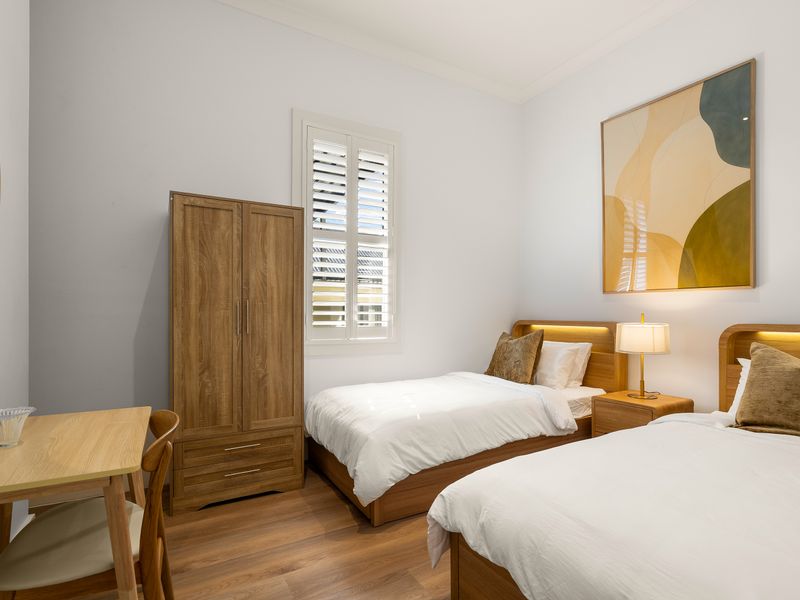 Flexible bedroom with two single beds and wardrobe storage.