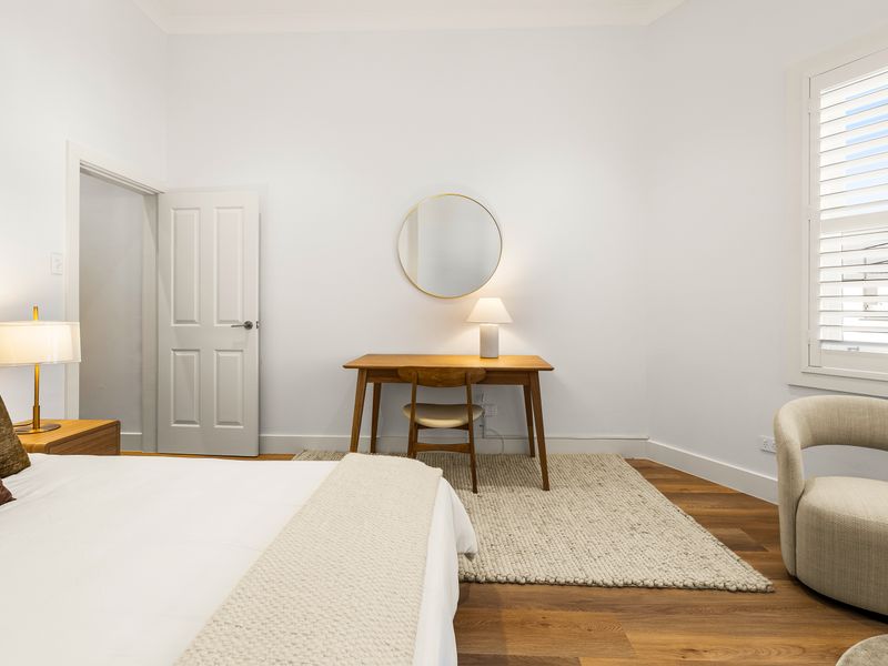 Relaxing bedroom with natural light and a dressing table.