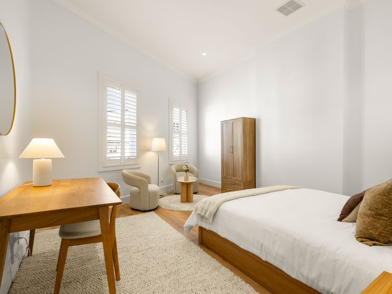 Bright bedroom with a comfortable bed and dedicated workspace.