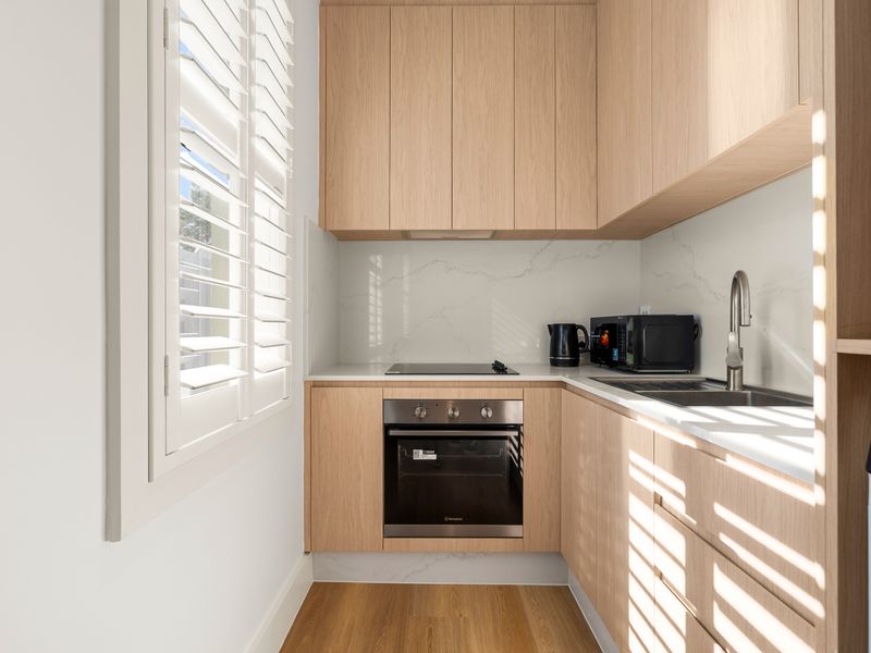 Fully equipped kitchen with oven, cooktop and modern appliances.