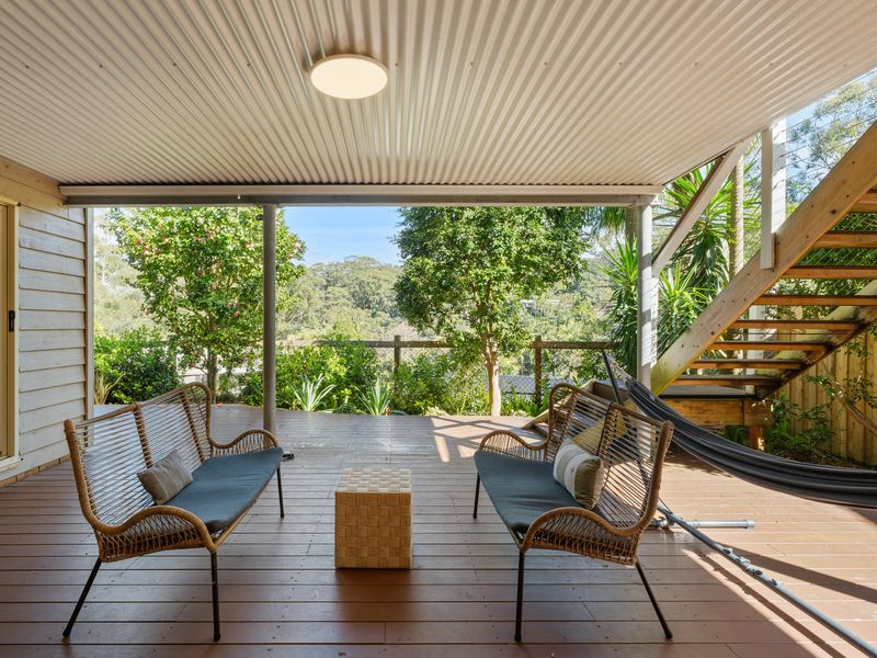 Relax in the shaded outdoor seating area surrounded by lush greenery