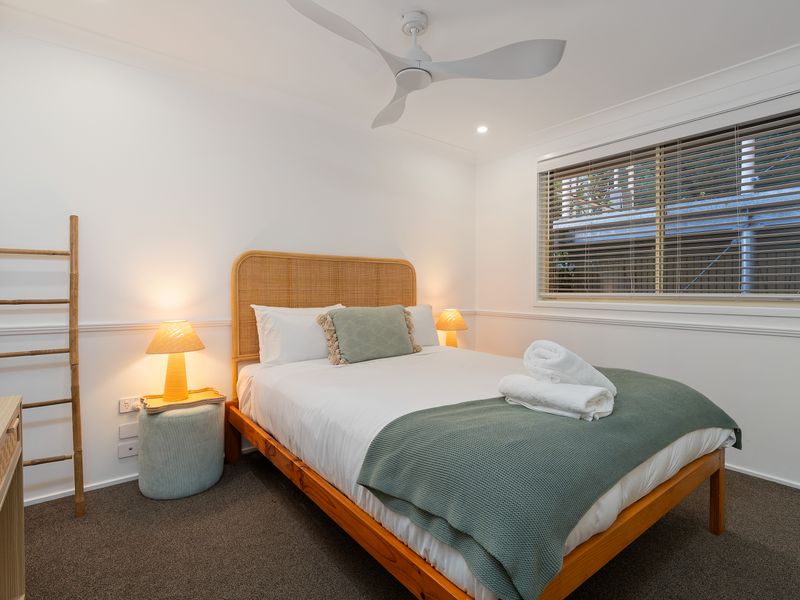 Comfortable queen bedroom with fresh linen and a relaxed coastal feel