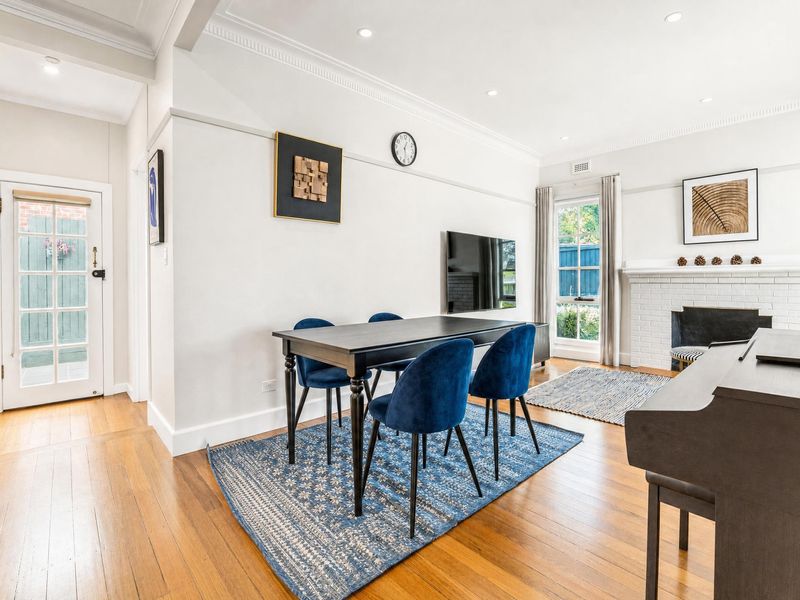 Elegant dining space with a table, chairs, and a piano.
