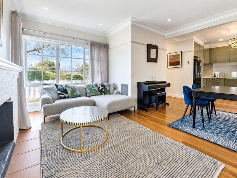 Bright living area with a fireplace opening into the dining space.