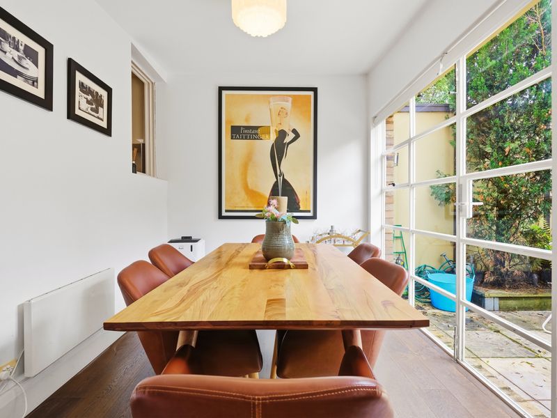 Elegant dining space next to large windows overlooking greenery