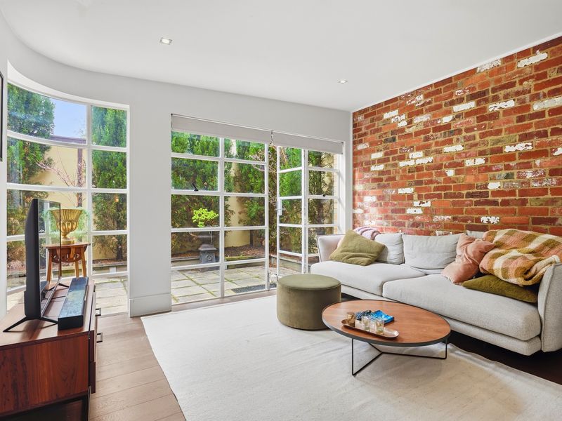 Bright living area featuring an exposed brick wall and cozy sofa.