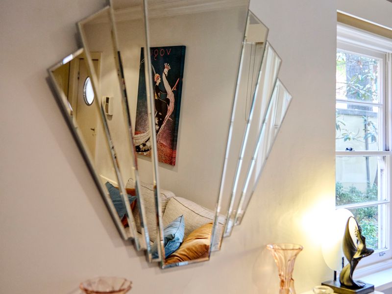 Stylish geometric wall mirror reflecting chic interior design details.
