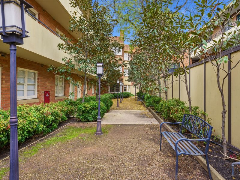 Quiet outdoor pathway through the property grounds with a garden bench.