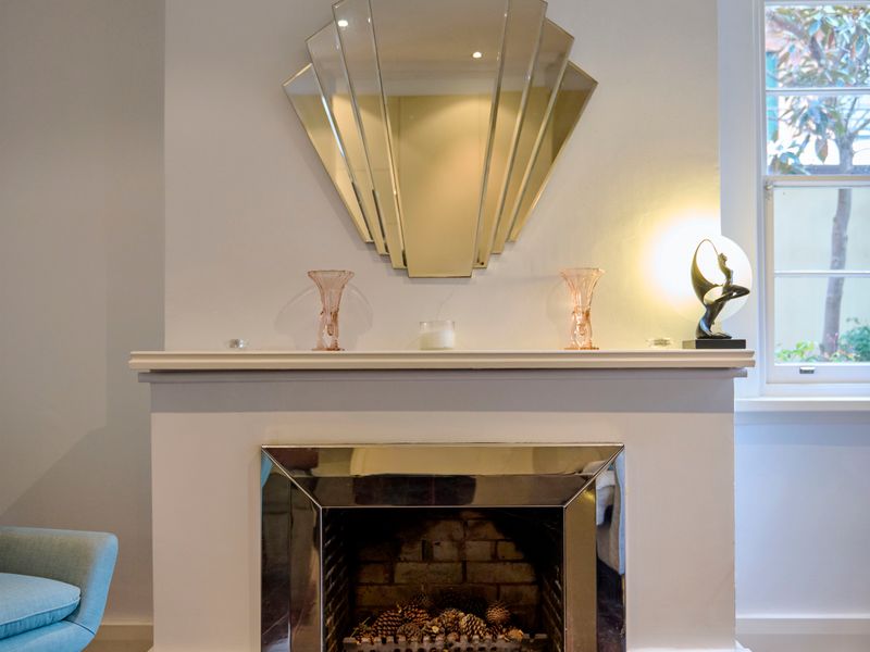 Elegant fireplace mantle featuring a statement mirror and accents.