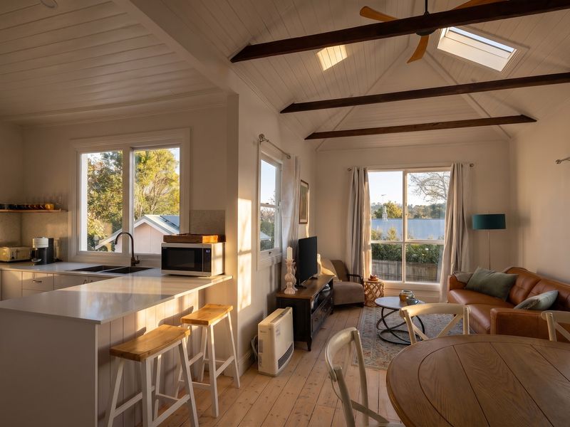 Bright open-plan living and dining area with exposed beams