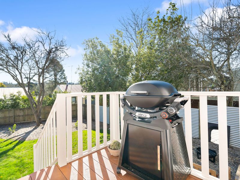 Outdoor deck area equipped with a barbecue grill and scenic green views.