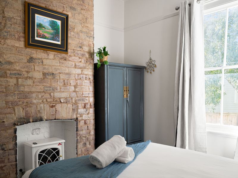 Charming room detail showcasing a decorative fireplace and exposed brick wall.