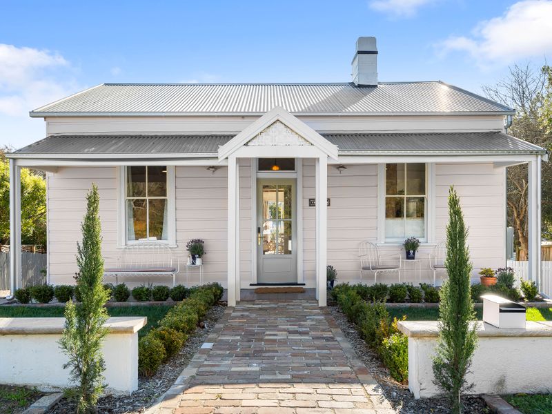 Charming exterior view of the house with a manicured front garden and paved entryway.