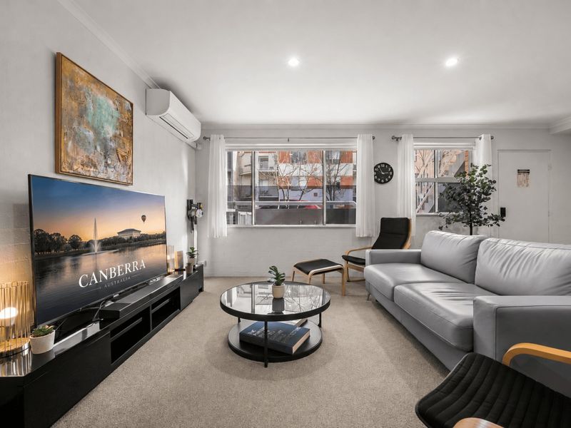 Cozy living room view featuring a stylish sofa and lounge chair.