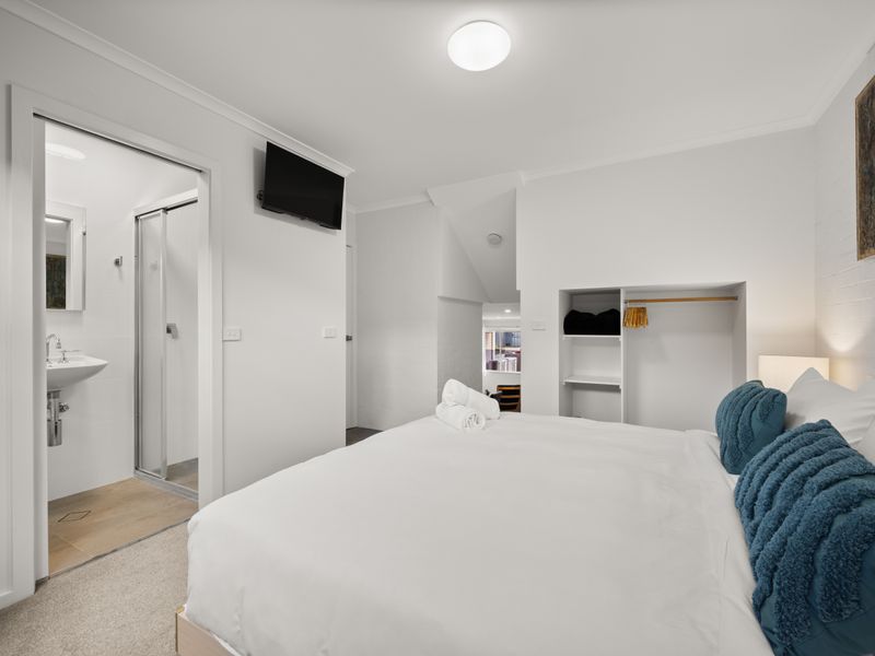 Comfortable bedroom view with a wardrobe mirror and neutral tones.