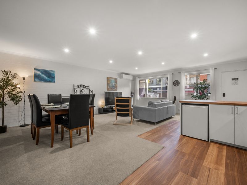 Wide view of the open living, dining, and kitchen layout.