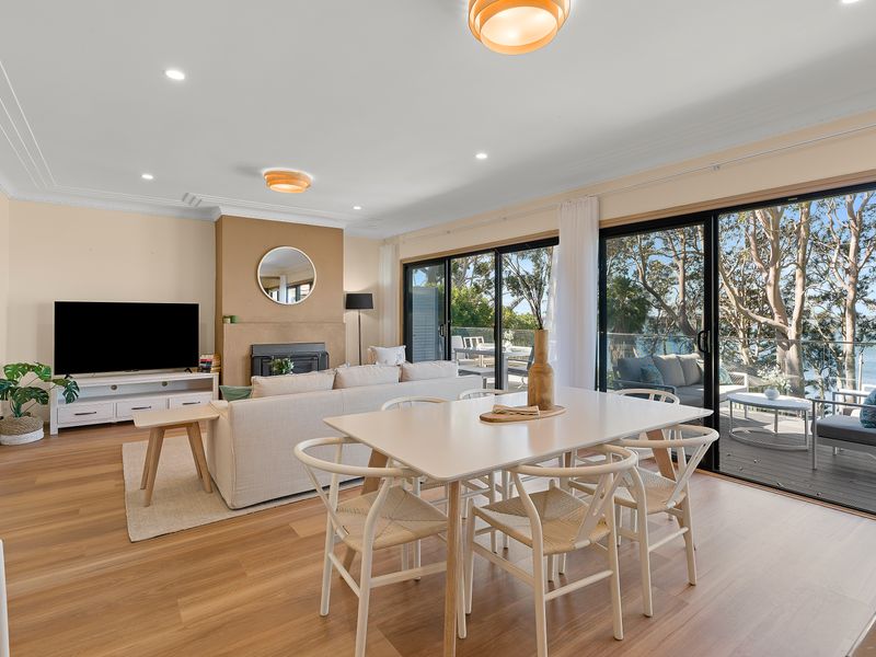 Open plan living, dining table and water views