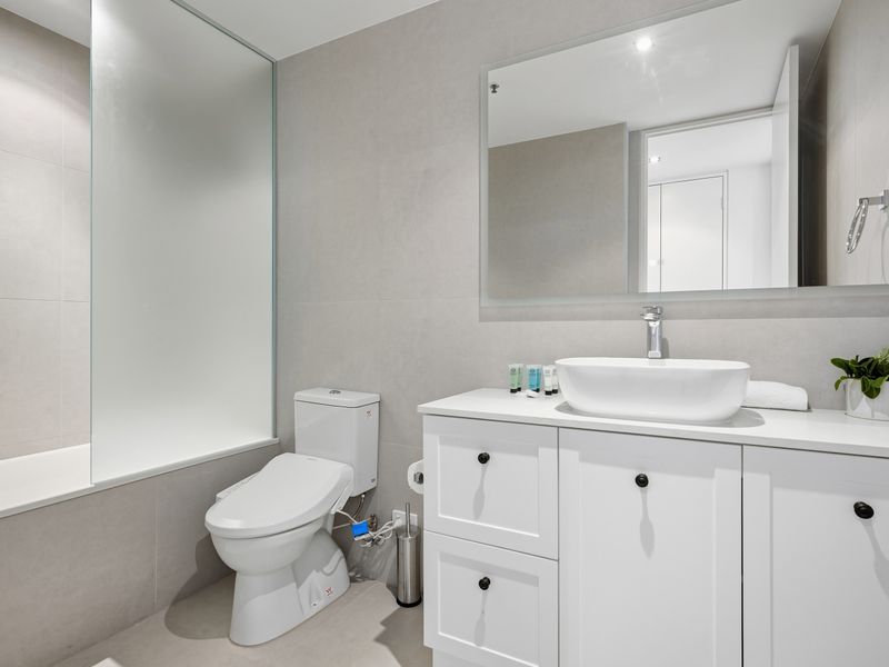 Clean and modern bathroom with a white vanity and toilet.
