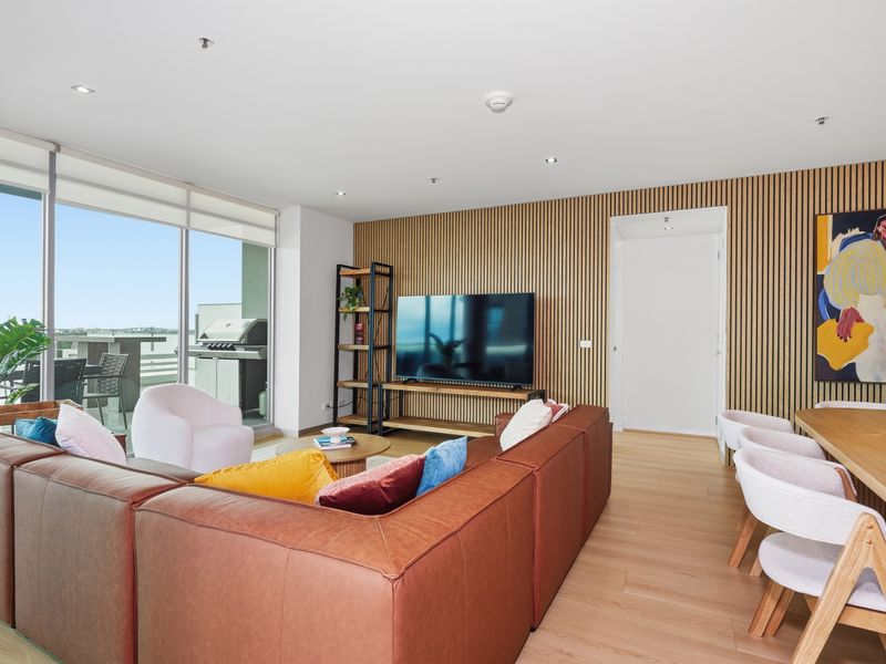 Open-plan living room with a large sectional sofa and television setup.