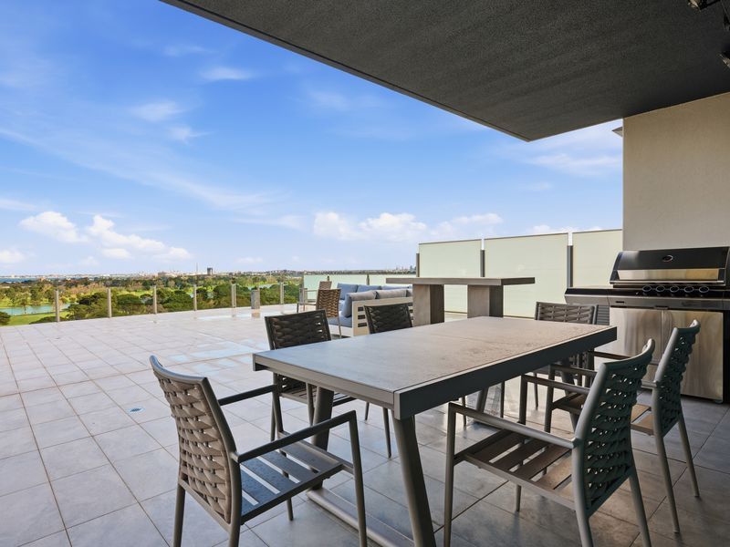 Covered patio table and chairs overlooking the open rooftop space.