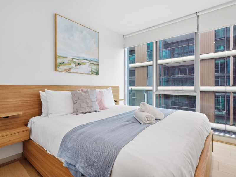 Queen bedroom featuring a wooden headboard and sliding window views.