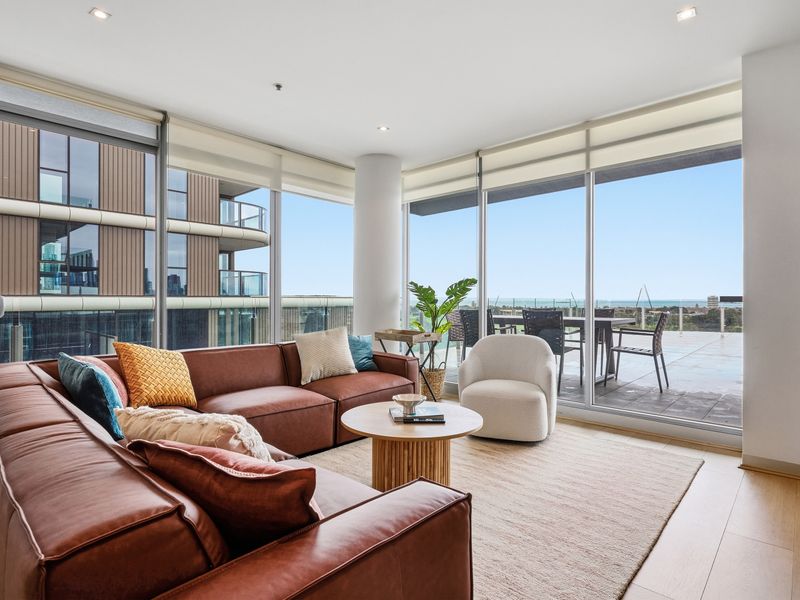 Spacious living room featuring a comfortable leather sofa and floor-to-ceiling windows.