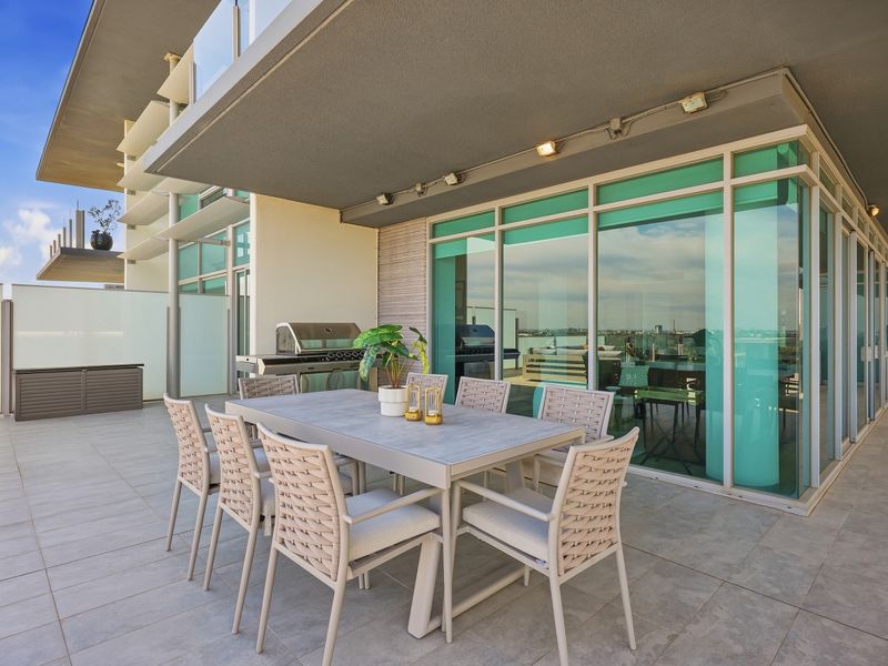Elegant outdoor dining terrace surrounded by glass and modern architecture.