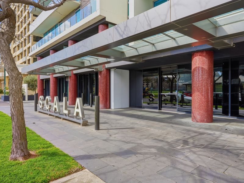 Front entryway approach of the apartment building under a covered canopy.
