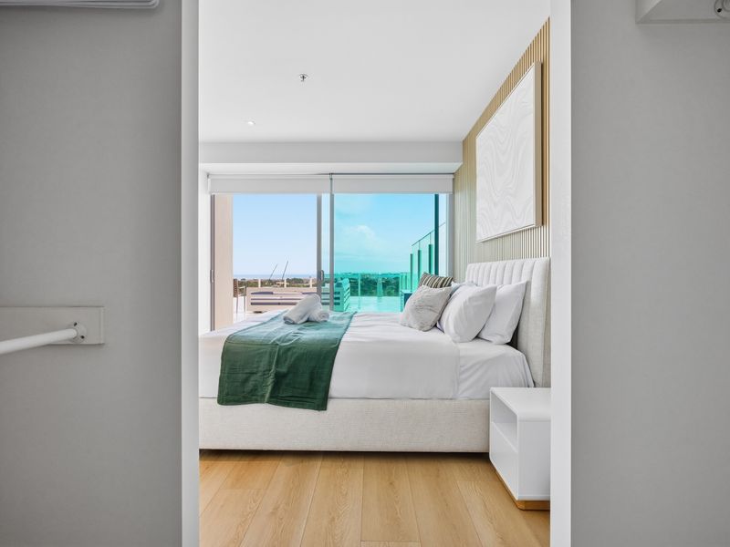 Bedroom view looking toward the bed and large windows with outdoor views.