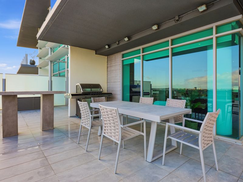 Outdoor terrace dining area with a modern table and chairs.