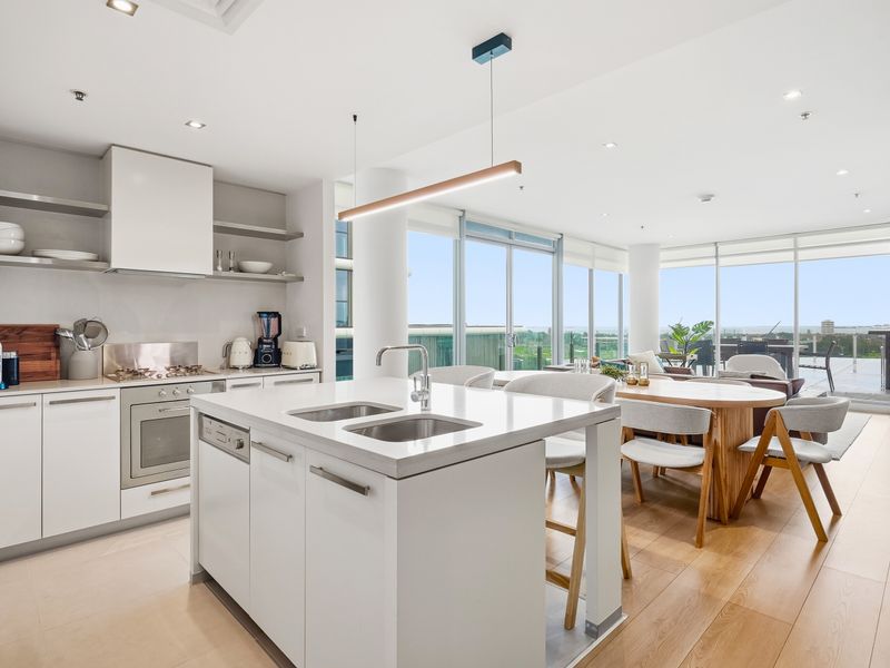 Sleek kitchen area equipped with white cabinetry and a central island.