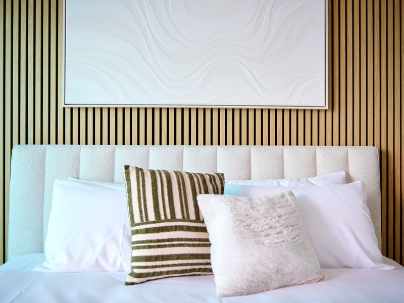 Modern bedroom with a neutral tufted headboard and stylish pillows.