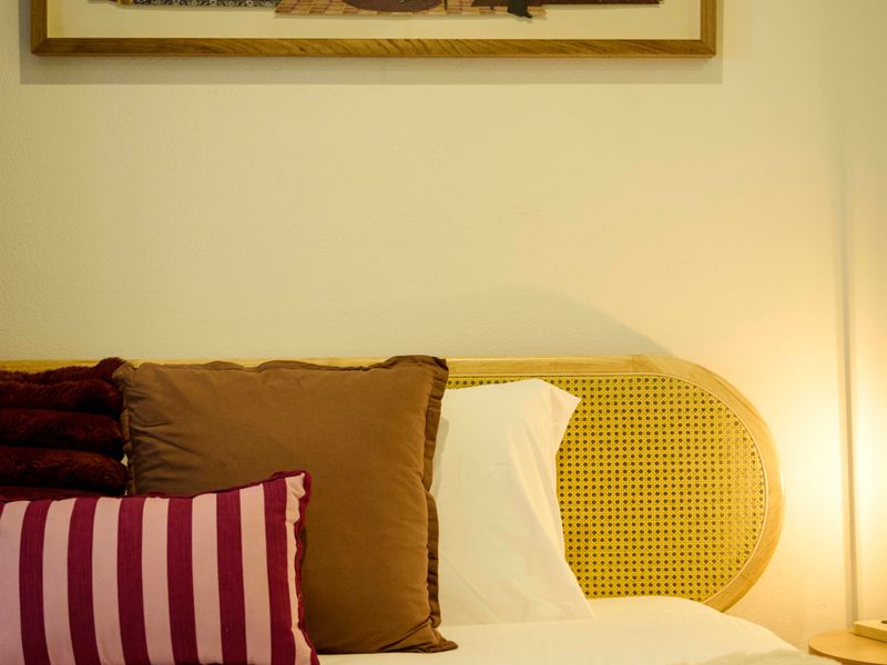 Soft bed headboard and plush pillows.