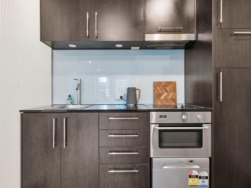 Modern kitchenette equipped with spacious cabinets, an oven, and stove.