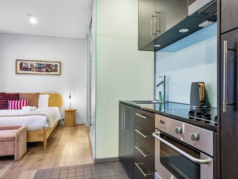 View looking from the bedroom area toward the modern kitchenette.