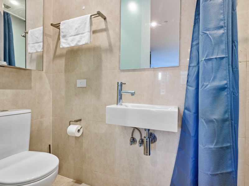 Clean and compact bathroom featuring a white vanity and toilet.