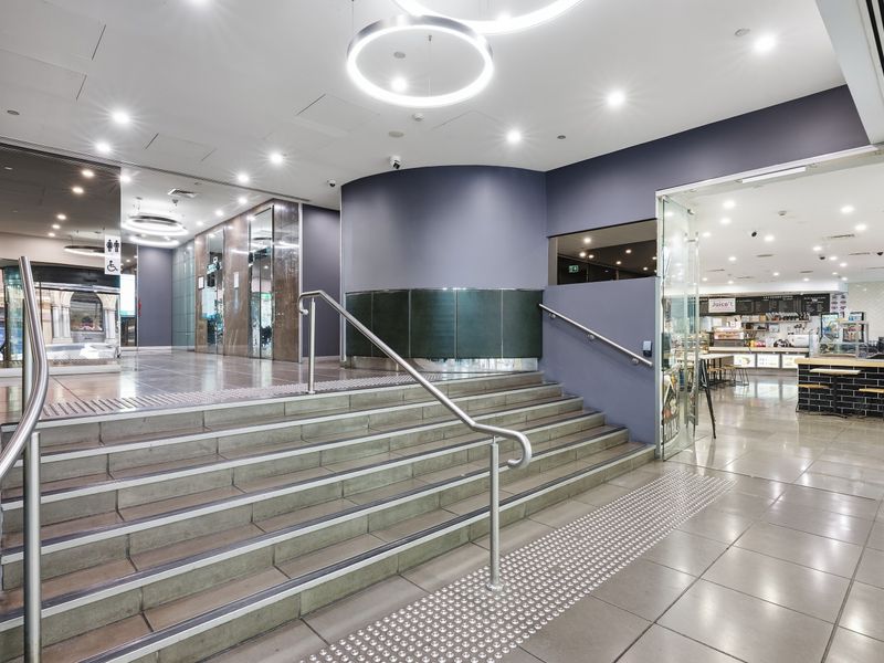 Modern lobby entrance with wide steps and a glass door.