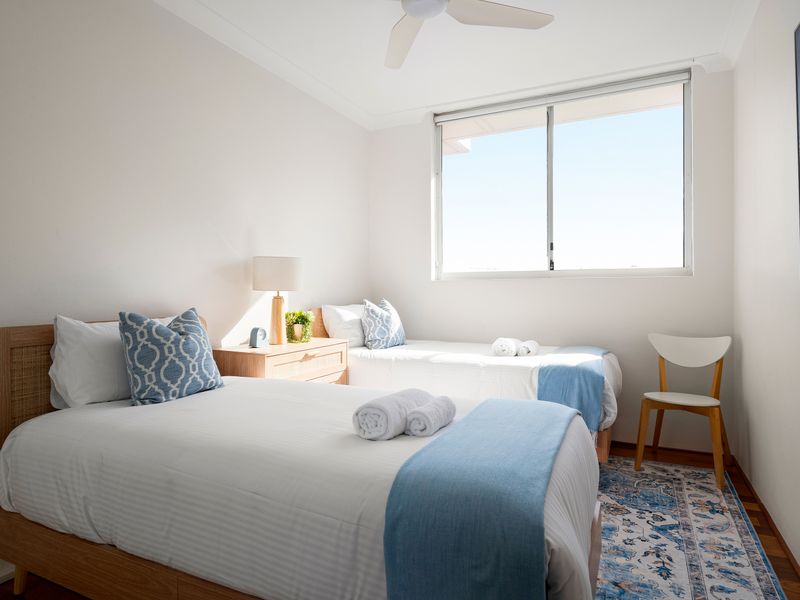 Bright, sunlit room with clean white walls and a large window.