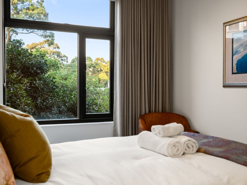 Alternative bedroom angle showing a bed styled with yellow accent pillows and a headboard.