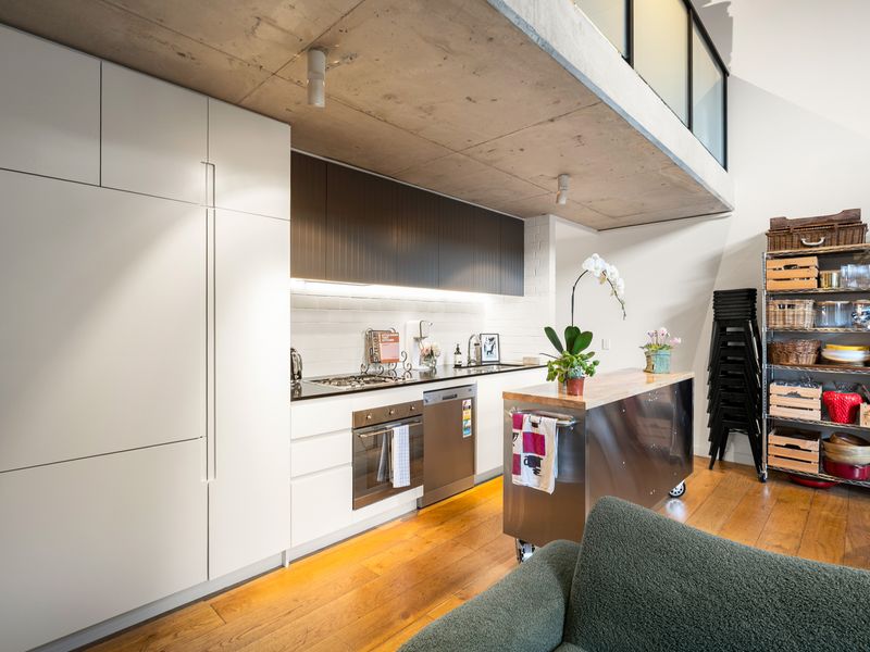 Open-concept kitchen and dining transition featuring a central island counter and rich timber bookshelves.