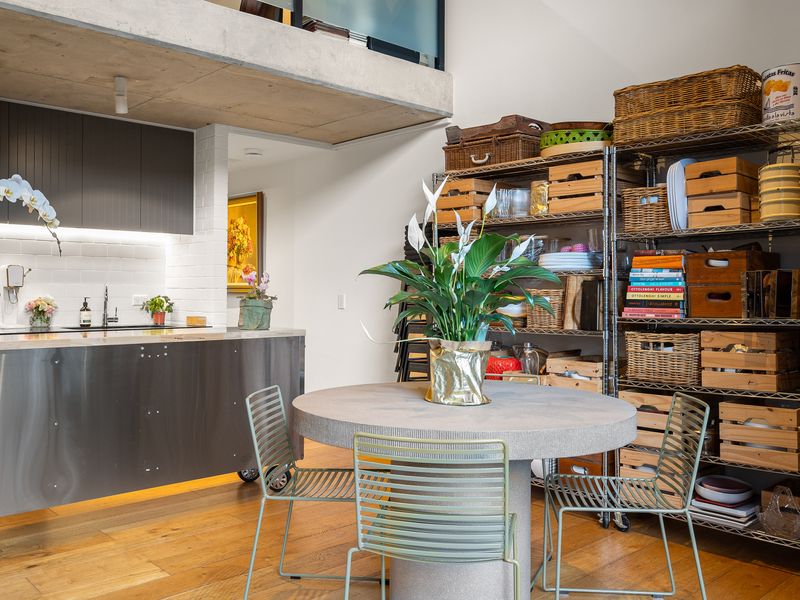 Open kitchen counter setup paired with shelving units storing kitchenware.