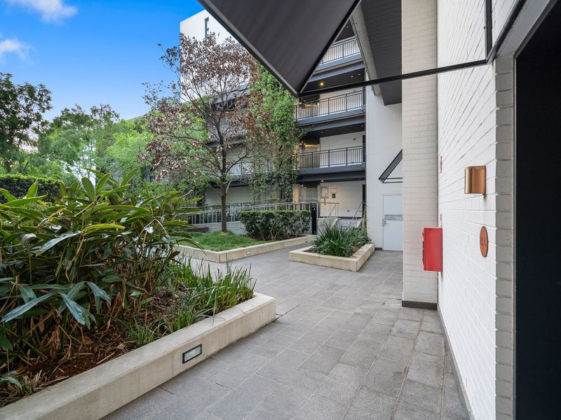 Exterior walkway leading through landscaped garden paths of the apartment complex.