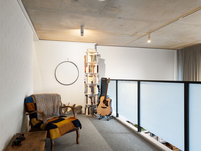 Cozy second-floor lounge nook arranged with a comfortable armchair and soft ambient lighting.