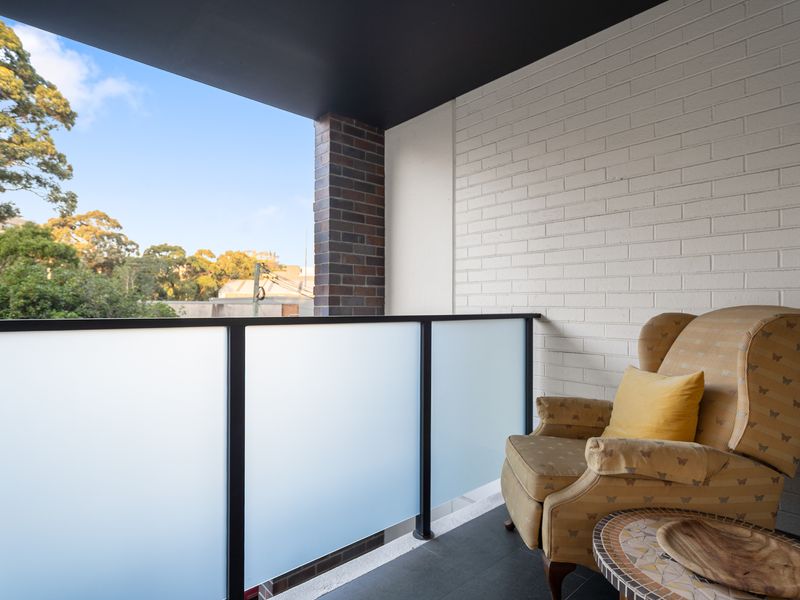 Private balcony featuring an armchair and frosted glass privacy panels.